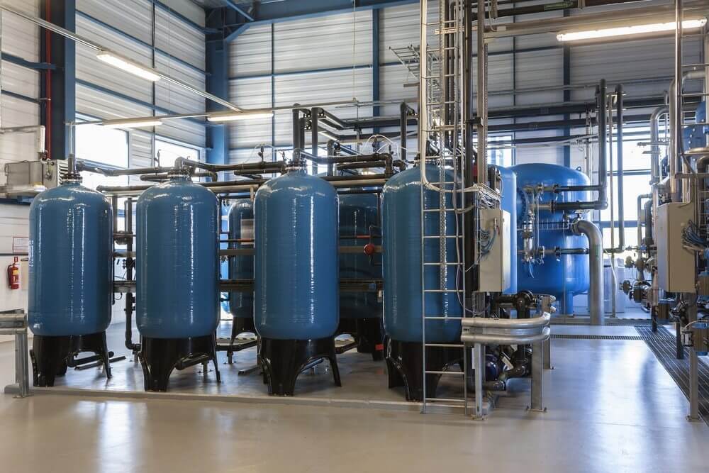Multiple Commercial and Industrial Water Treatment System tanks and pipes shown in an industrial facility.